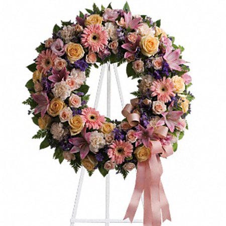 Pastel circle flower wreath standing funeral spray delivery at Send Flowers