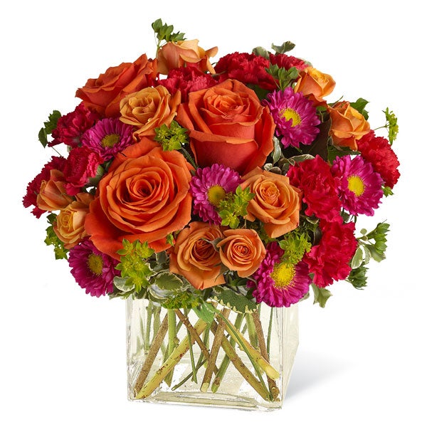 A Bouquet of Light Orange Roses, Orange Spray Roses, Hot Pink Carnations, and Matsumoto Asters in a Clear Glass Vase