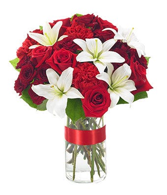Elegant red rose bouquet with white lilies and red carnations in a cylinder vase