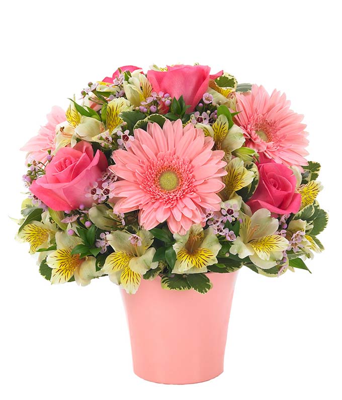 Pink roses, pink gerbera daisies and yellow alstroemeria in pink vase