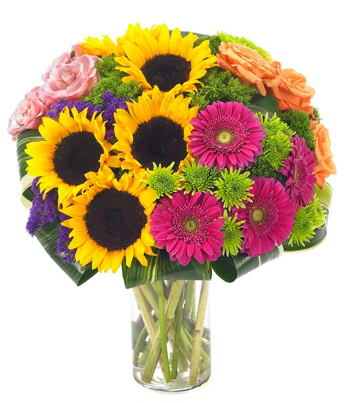 Sunflowers, purple statice, hot pink gerbera daisies and orange roses in glass vase