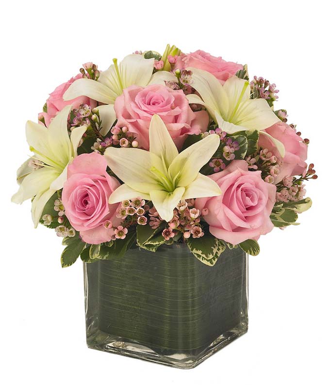Pink roses with white lilies delivered by a florist in a square vase