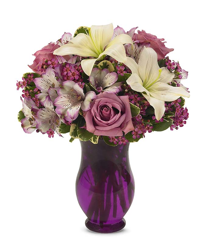 Purple flowers arranged in a purple vase, available for flowers delivered today