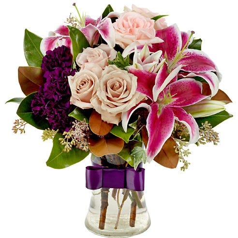 Light pink roses, hot pink lilies and purple flowers in vase