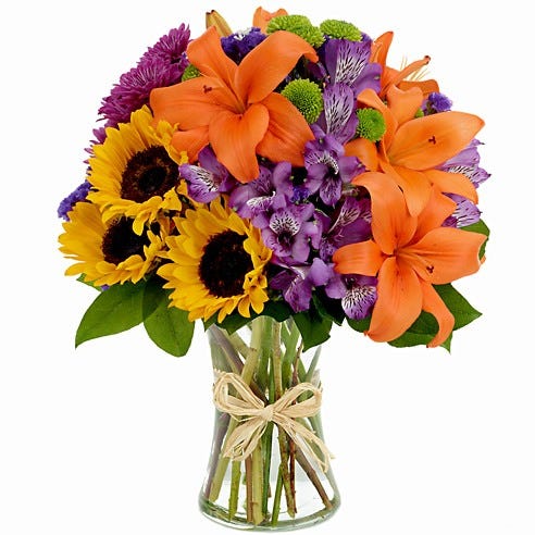 Sunflowers, daisies and orange lilies in cylinder vase
