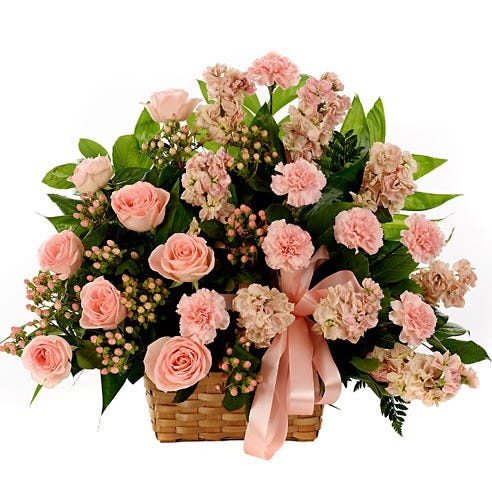 Pink roses, peach roses and peach hypericum in woven basket