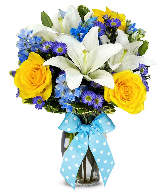 Orange roses, white lilies and blue flowers in vase
