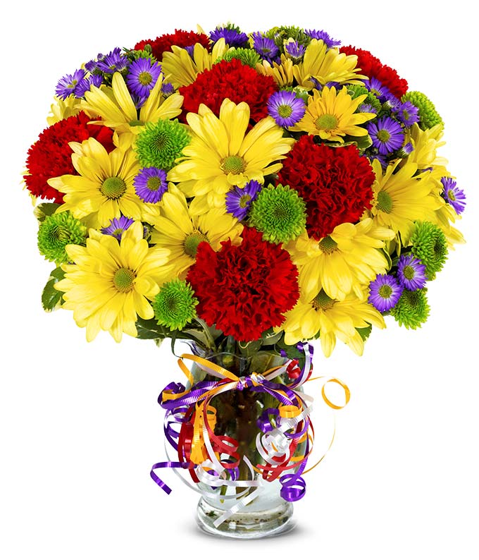 A Bouquet of  Red Carnations, Yellow Daisies, Purple Monte Casino, and Green Button Poms in a Glass Vase with Rainbow Ribbons