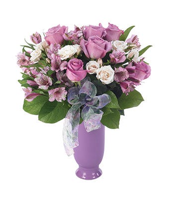 Purple flower bouquet with roses, alstroemeria and spray roses in a purple vase