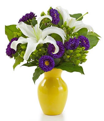 White lilies with blue flowers in a yellow vase