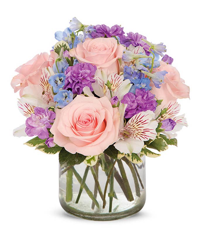 Rainbow flowers in a clear vase with happy birthday balloon