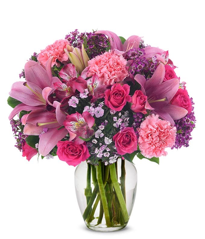 pink spray roses, carnations and asiatic lilies in a pink vase for delivery