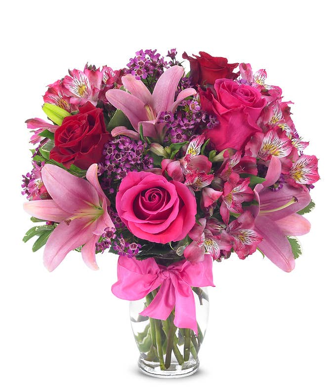 A Bouquet of Red And Pink Roses, Hot-Pink Asiatic Lilies and Fuchsia Alstroemerias in a Glass Vase with Bow and Message Card