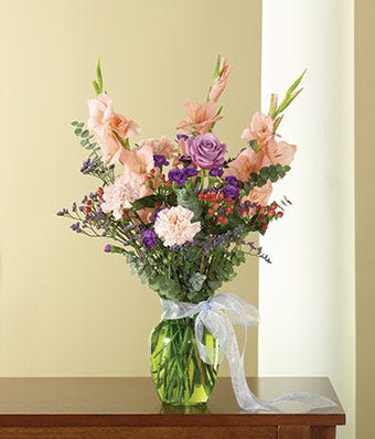 Coral Gladiolus, Peach Carnations & Lavender Spray Roses in a Vase				