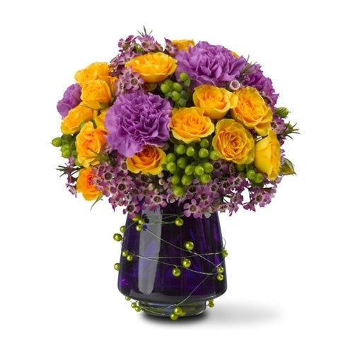 Purple flowers with yellow roses delivered in a purple vase