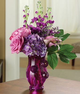 Purple roses, hydrangea and calla lilies in purple vase