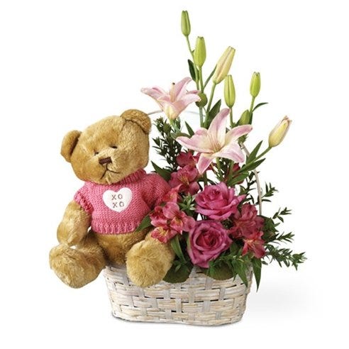 Pink flowers delivered in a basket with a teddy bear