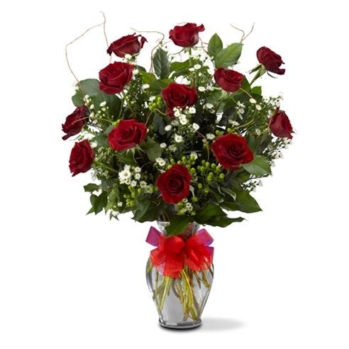 One dozen red roses arranged with hypericum, salad and willow in a glass vase