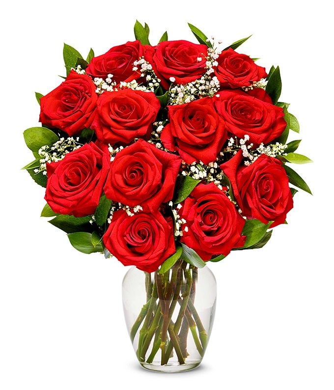 A bouquet of 12 long stem roses on a clear vase