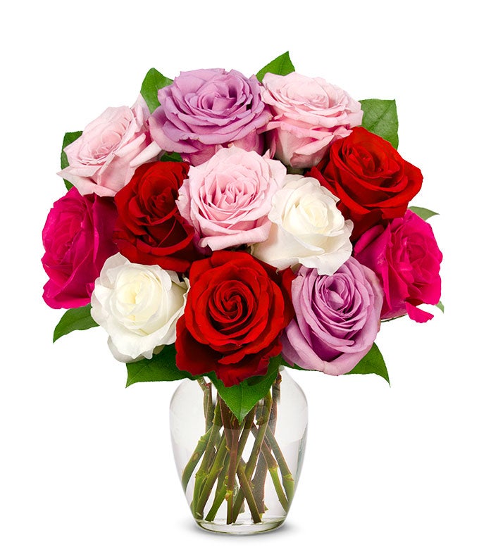 A bouquet of Red, Pink, Lavender, and White Long Stem Roses in a clear vase