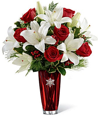 Winter flower arrangement with red roses and white lilies delivered in a decorative vase