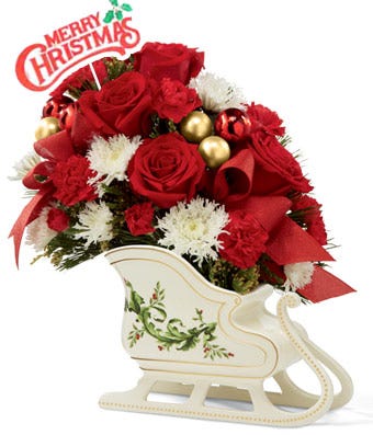 Red roses and white flowers arranged in a sleigh for a christmas gift