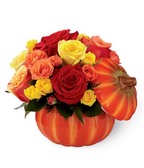 Red roses and yellow roses in a pumpkin vase