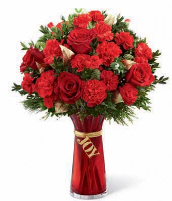 red roses and red carnations in a red glass vase that says Joy
