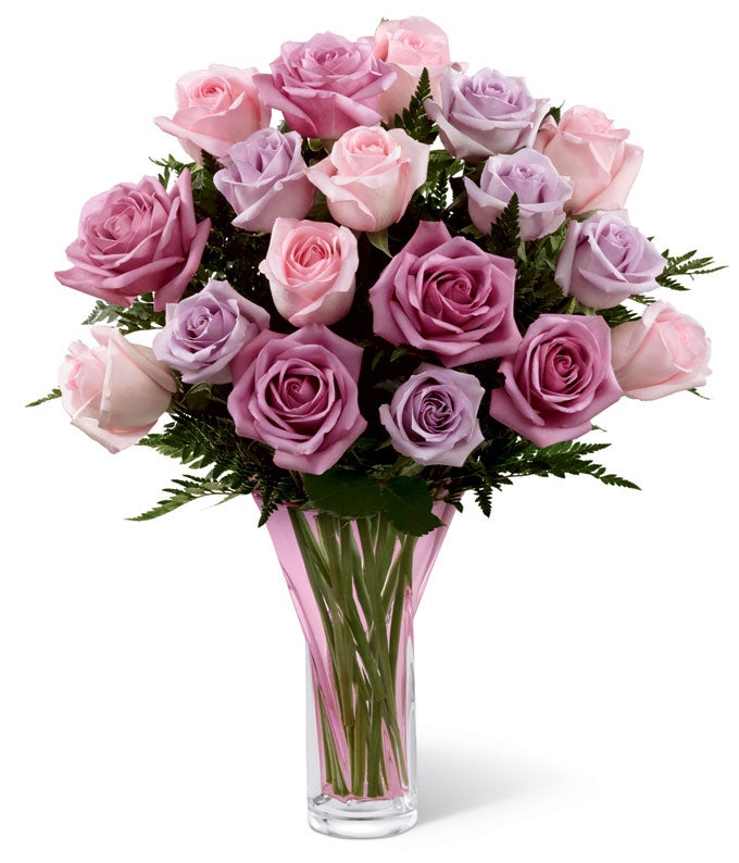 A Bouquet of Long Stem Pink, Lavender, and Light-Purple Roses in a Designer Blush Glass Vase