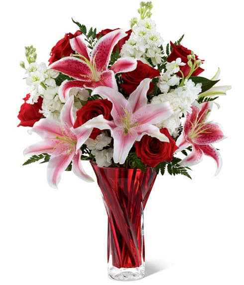 Red and pink stargazer lily bouquet with white stock flowers in red vase