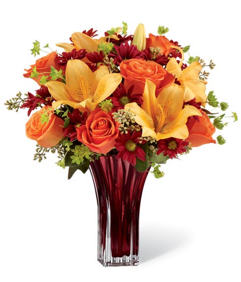 Peach lily and orange rose flower bouquet with dark brown glass vase