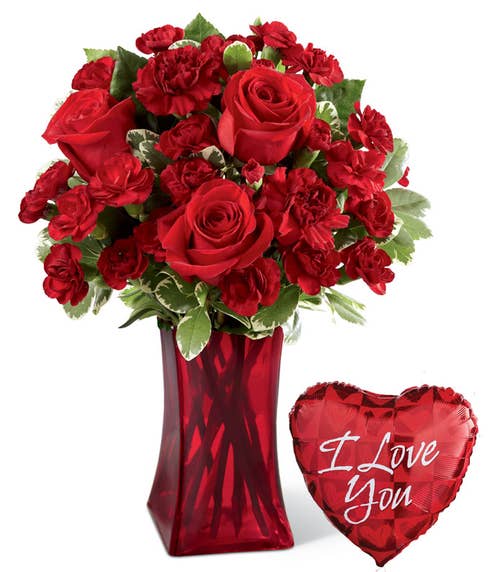 Red roses and red mini carnations in a red vase with an I Love You balloon