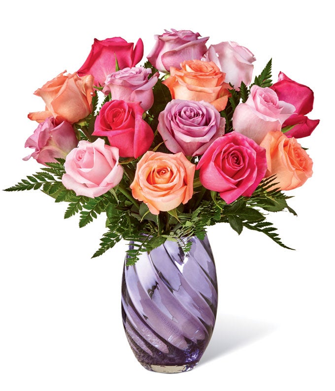 A Bouquet of Hot-Pink, Coral, Lilac, And Pink Roses in a Glass Vase