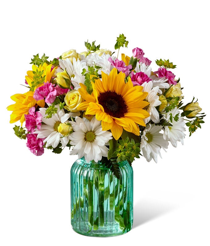 A Bouquet of White Daisy Pompons, Yellow Button Pompons, Sunflowers, Lavender Mini Carnations, Bupleurum, Canary Spray Roses and Leatherleaf in a Keepsake Vase