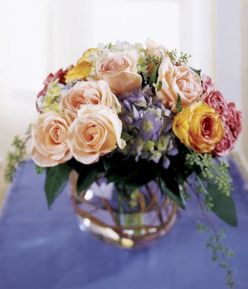 Peach roses, purple hydrangea and mixed flowers in a circle vase