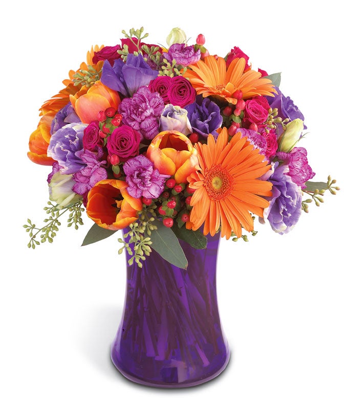 A Bouquet of  Orange Tulips, Orange Gerbera Daisies, Petite Fuchsia Spray Roses, Purple Lisianthus and  Purple Mini Carnations in a  Purple Vase