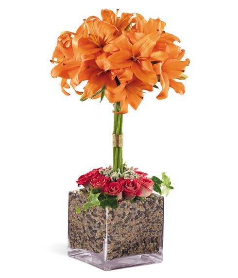 Orange lily flower topiary arrangement with square glass vase and pink roses