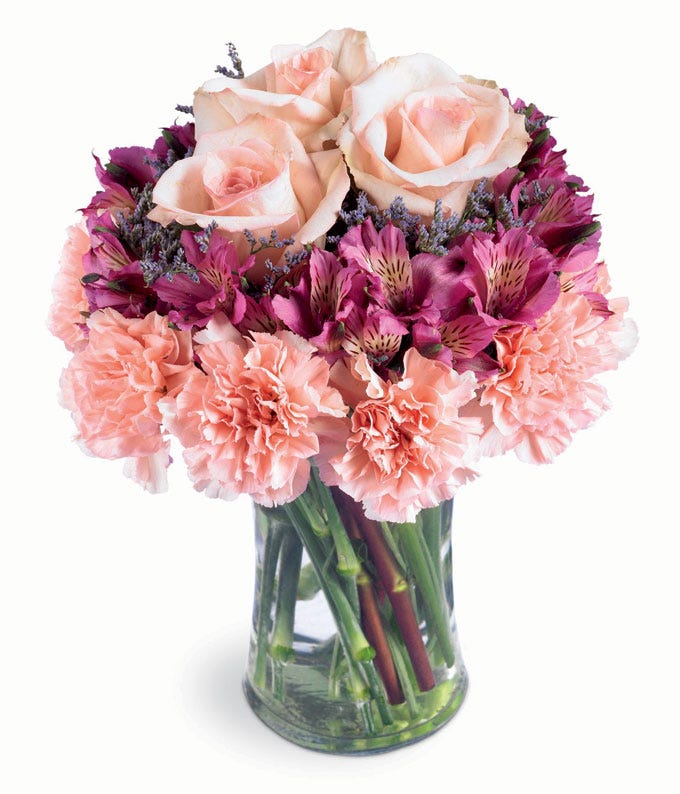Pink carnations and lavender alstroemeria in a glass vase
