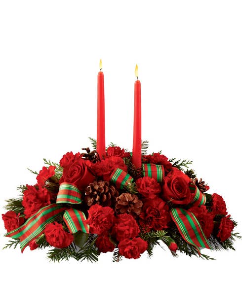 Flower centerpiece of red roses and red carnations with tapered candles