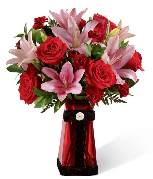 Long stem red roses, red mini carnations and pink lilies in a red vase