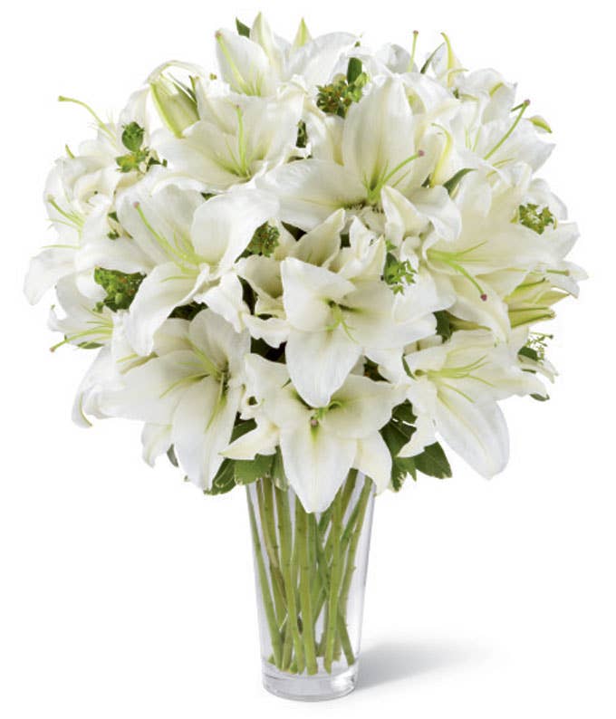 A Bouquet of  White Oriental Lilies and Fresh Greens in a Clear Glass Vase