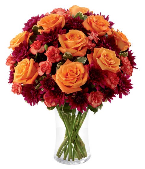 Orange roses and red mini carnations in Fall bouquet
