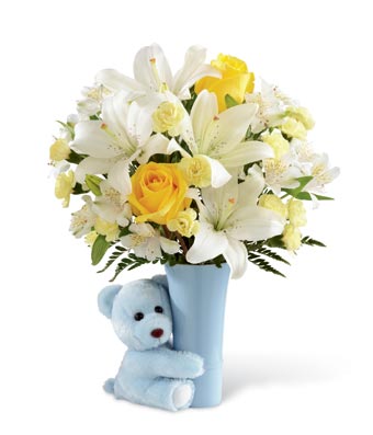 A bouquet of yellow roses, light yellow carnations, white Peruvian lily, and white Asiatic lilies on a blue vase with a blue teddy bear hugging it