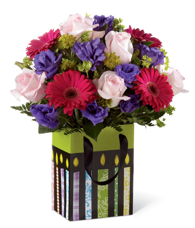 Birthday flowers for same day flower delivery inside a striped gift bag