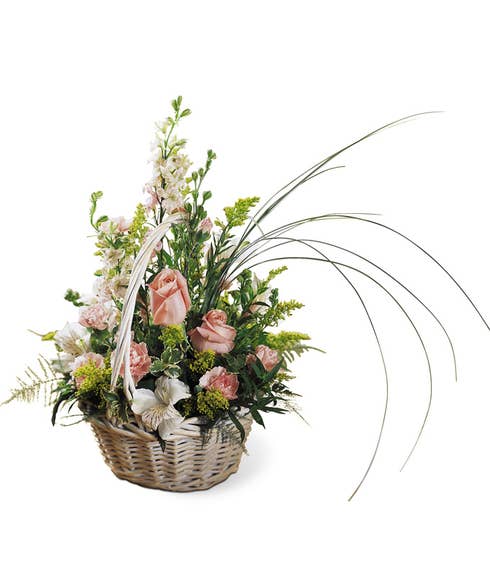 Peach roses and pink flowers delivered in a basket