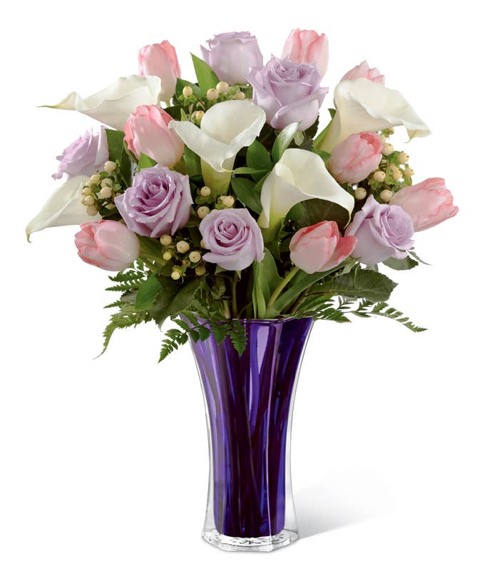 A Bouquet of Pale Pink Tulips, White Open-Cut Calla Lilies, Lilac Colored Roses and Peach Hypericum Berries in a Violet Flared Glass Vase