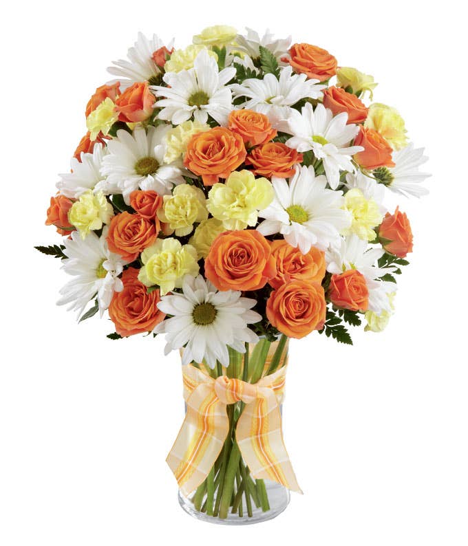 A Bouquet of Orange Spray Roses, Yellow Mini Carnations and White Daisies in a Clear Glass Vase