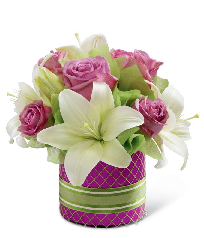 Lavender roses and white Asiatic lilies in a cylinder glass vase