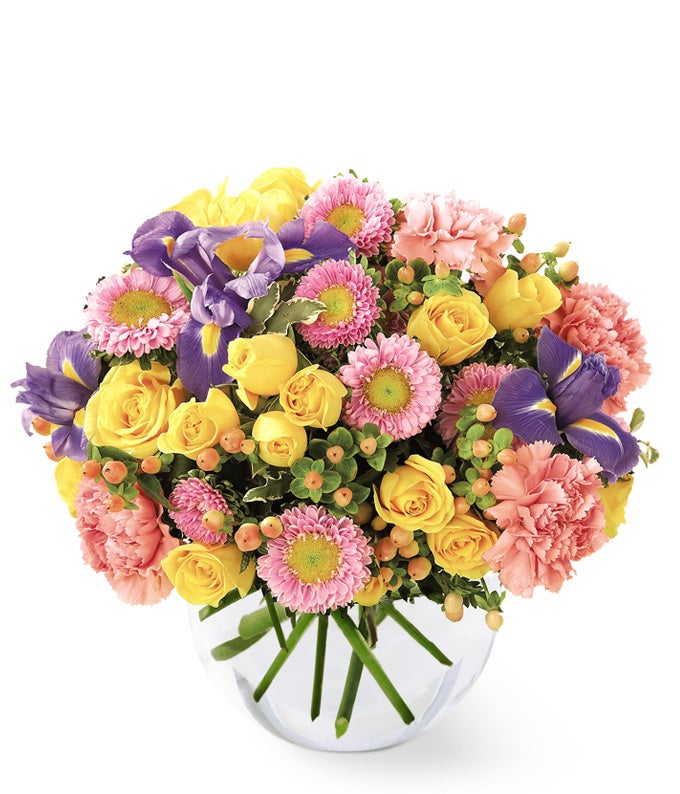 A Bouquet of Yellow Spray Roses, Pink Carnations, Asters, and Blue Iris in a Bubble Vase