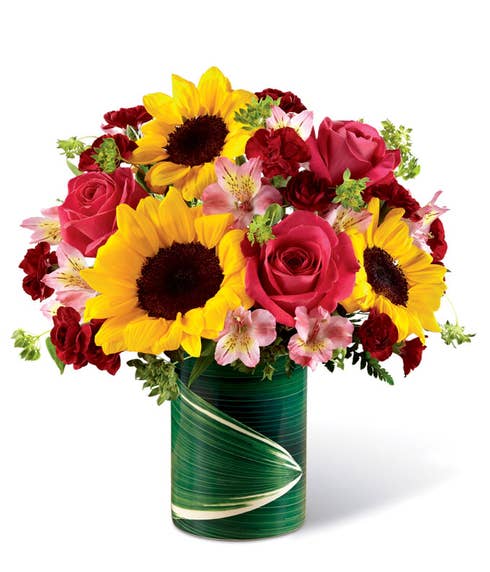 Mixed sunflower and pink rose summer flowers bouquet with leaf vase